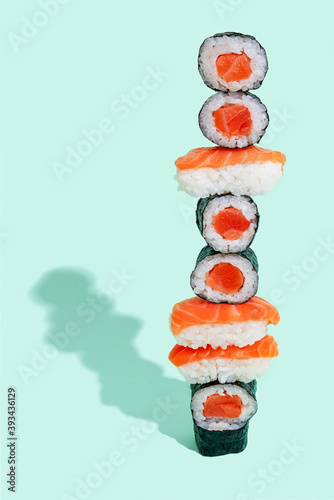 Salmon sushi with nigiri and maki pattern on mint green background