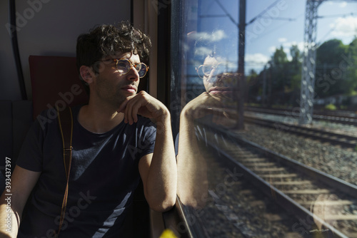 Man traveling by train looking out of window