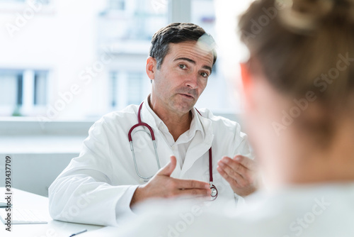 Portrait of doctor talking to patient in medical practice