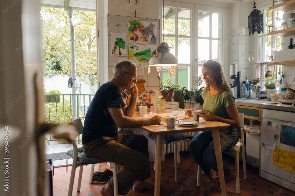 Mature couple sitting at kitchen table at home Mature couple sitting at kitchen table at home