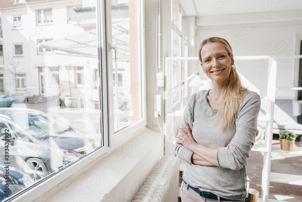 Portrait of smiling woman standing at the window Portrait of smiling woman standing at the window