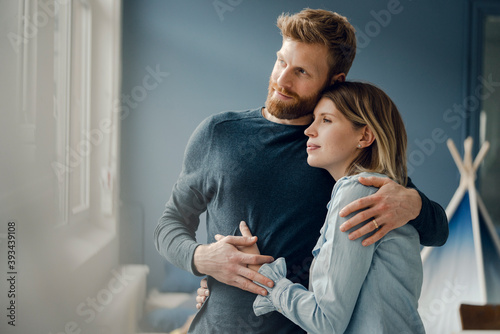 Happy couple embracing at home