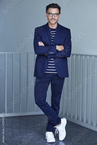 Portrait of fashionable businessman with wearing blue suit and glasses