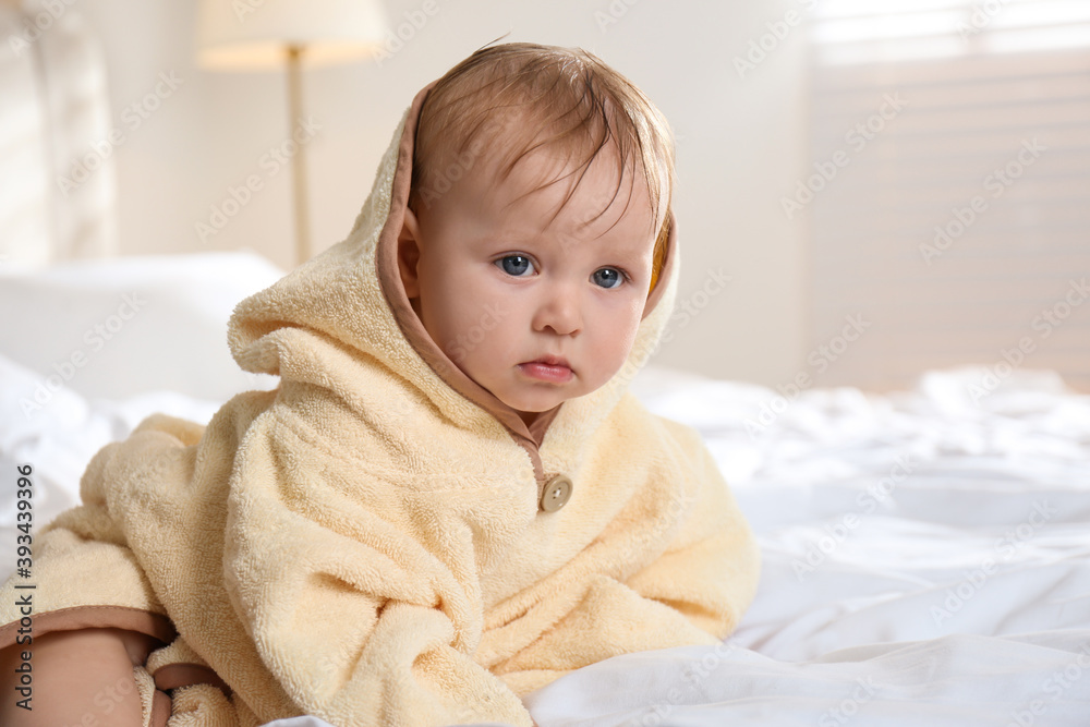 Φωτογραφία Cute little baby in yellow hooded towel on bed after bath