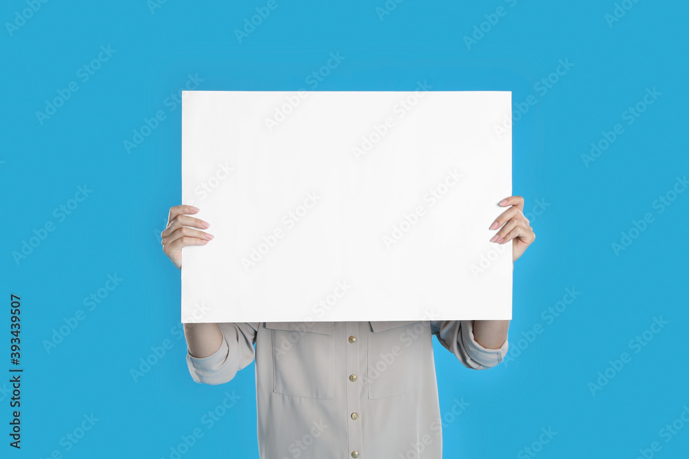 Woman holding blank poster on blue background Woman holding blank poster on blue background