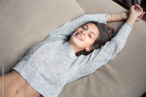Portrait of happy woman lying on couch photo