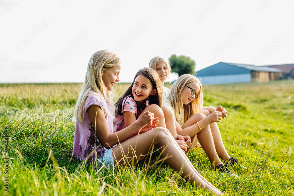 Girls sitting on a field in the countryside Girls sitting on a field in the countryside