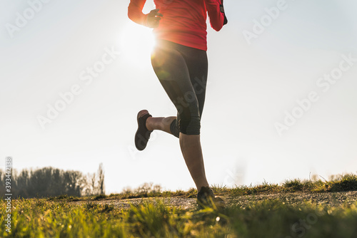 Low section of woman running on rural path photo