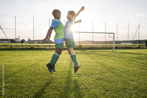 Young football players jumping on football ground