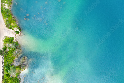Beach near the forest with clear blue water. photo