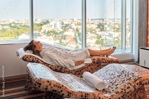 Senior female reclining on lounge chair at health spa