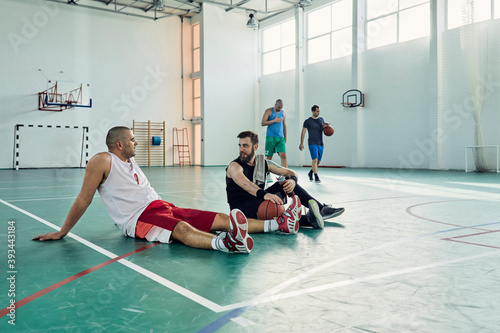 Basketball players during break, sitting on court photo