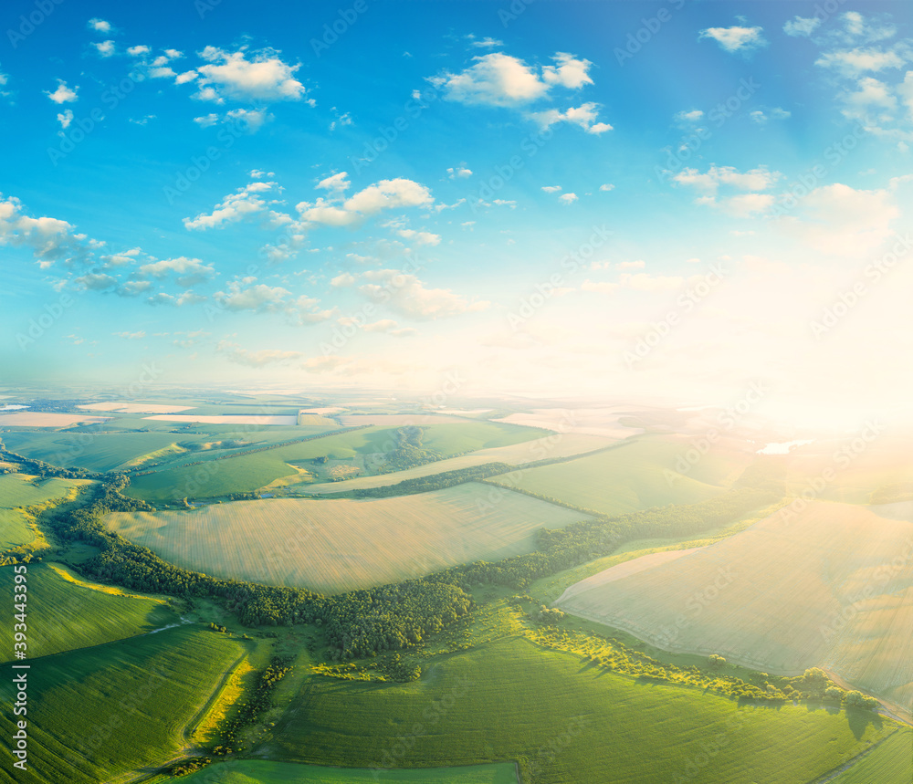 Fototapeta premium Aerial view of the sunset over the green fields.
