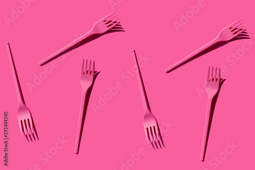 Pattern of pink plastic forks against pink background
