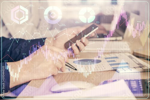 Double exposure of man's hands holding and using a digital device and forex graph drawing. Financial market concept.