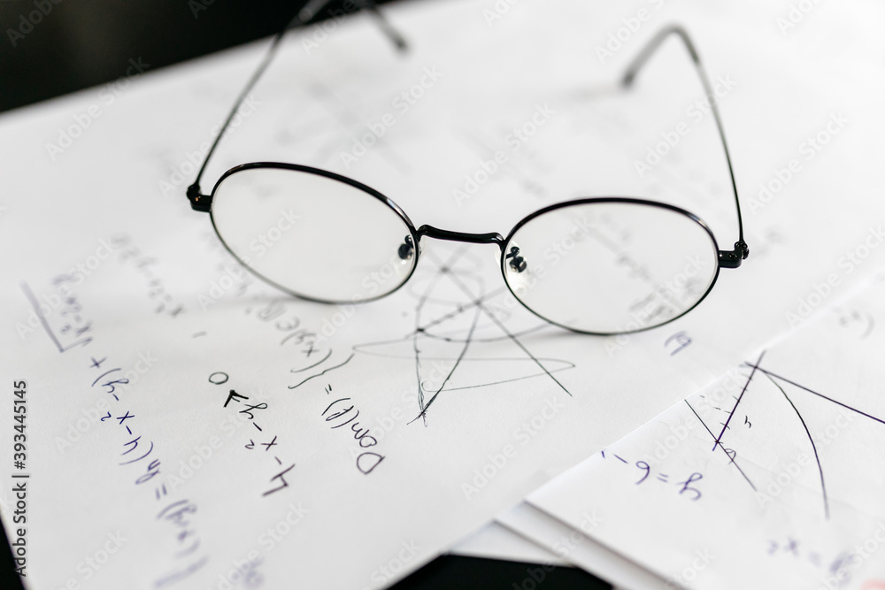 Close-up of eyeglasses on mathematics equations at home Close-up of eyeglasses on mathematics equations at home