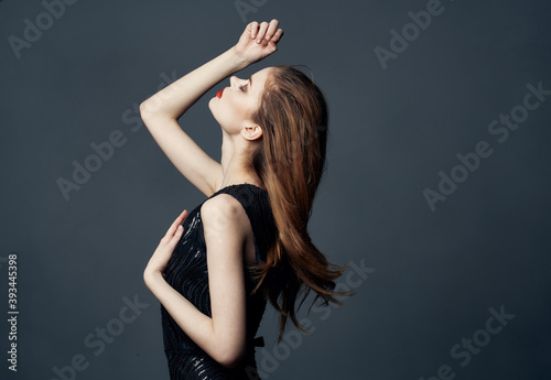 Red-haired Woman in a black dress posing on a gray background Copy Space Free Space
