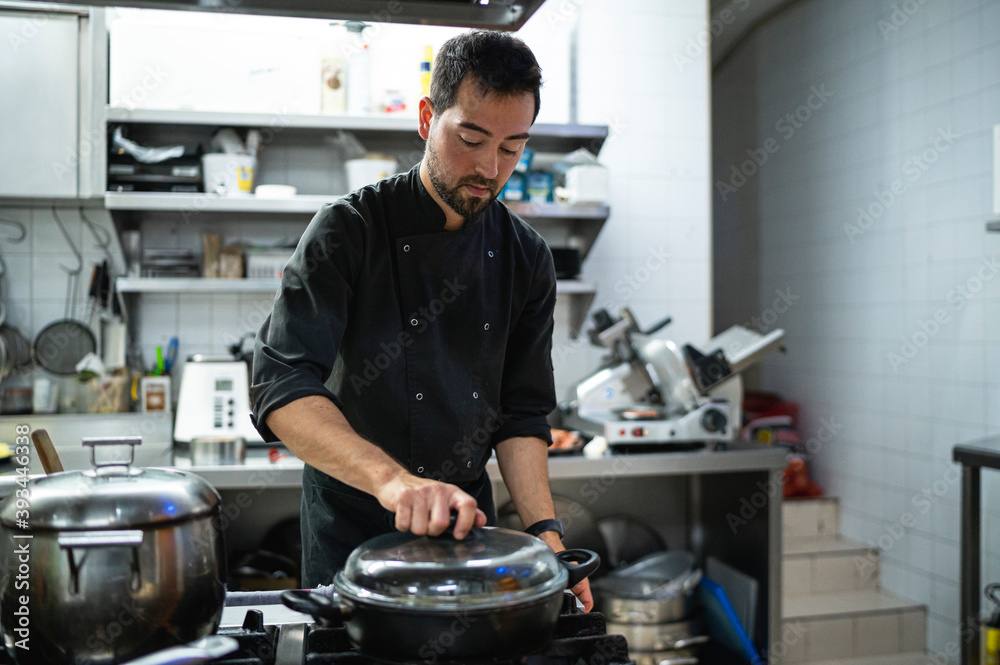 Man working while standing at commercial kitchen Man working while standing at commercial kitchen