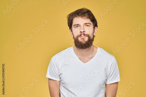 Bearded man on emotions white t-shirt fun lifestyle yellow background