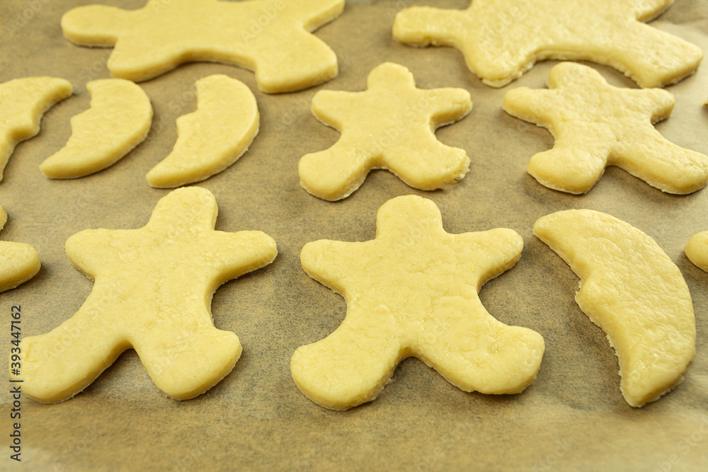 The Christmas gingerbread cookies are laid out on a baking sheet and ready to bake in the oven