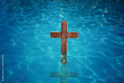 Leinwand Poster Wooden cross in water for religious ritual known as baptism