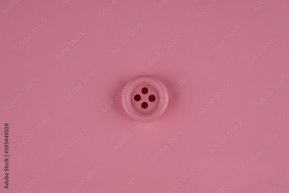 Minimal pink background with pink button in middle. Flat lay