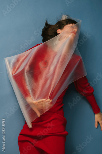woman with red dress and transparent plastic sheet photo