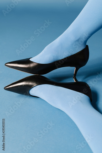 woman with black heels on blue background