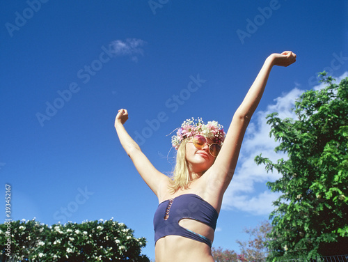 blonde teenager against bright blue sky being happy photo