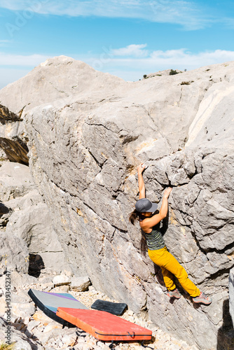 Sporty female climber overcomes challenging bouder photo