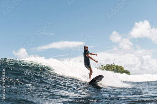 Skilled surfer on foamy wave walking on surfboard photo