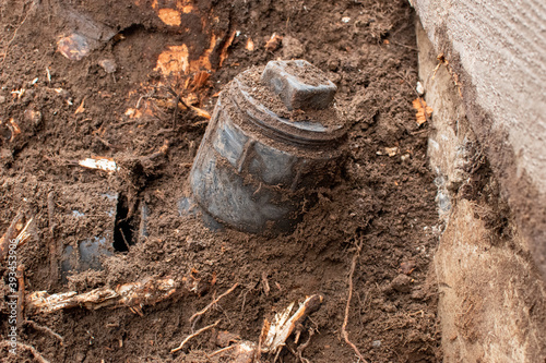 Broken main septic pipe caused by a tree growing next to the foundation of a home. photo