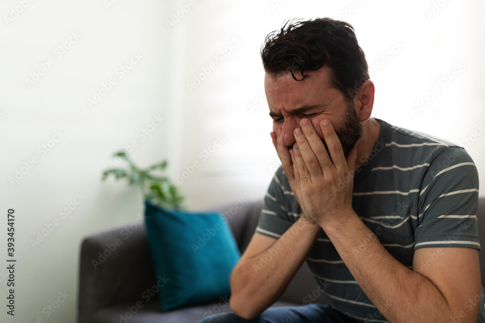 Depressed adult man touching his face Depressed adult man touching his face
