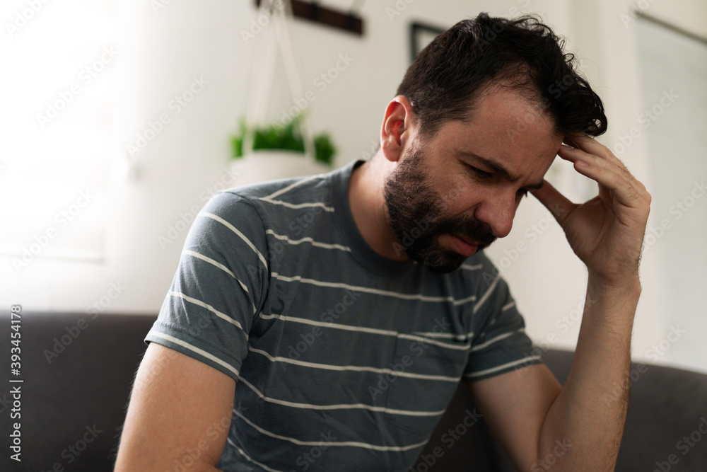 Latin man with depression on the sofa thinking about his problems Latin man with depression on the sofa thinking about his problems