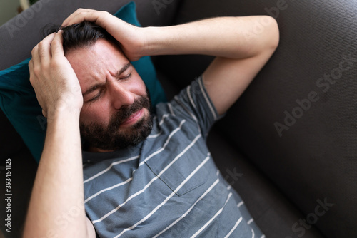 Adult man looking preoccupied on the couch