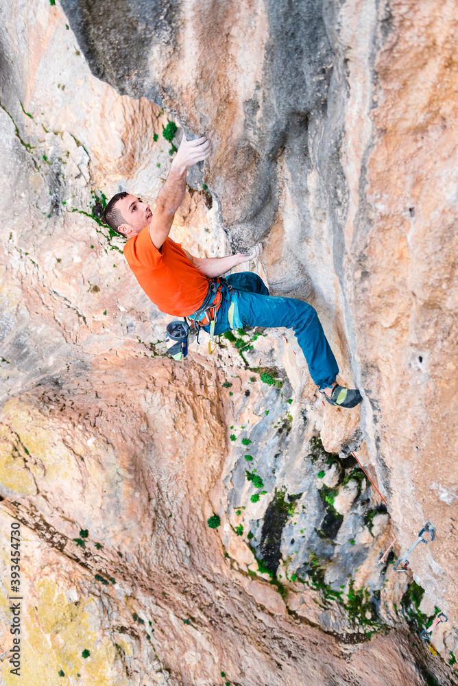 Sportive male alpinist climbing on cliff in Spain Sportive male alpinist climbing on cliff in Spain