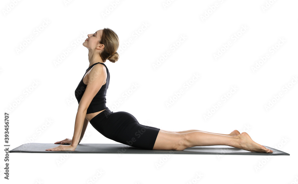 Young woman in sportswear practicing yoga on white background