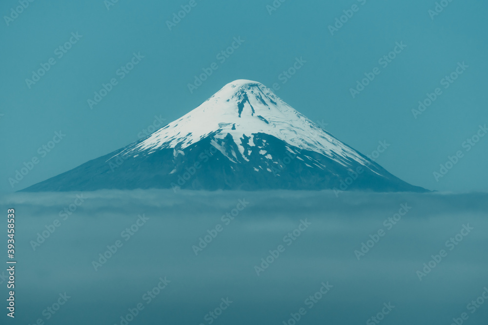 Osorno volcano seen from frutillar lake, surrounded by clouds
