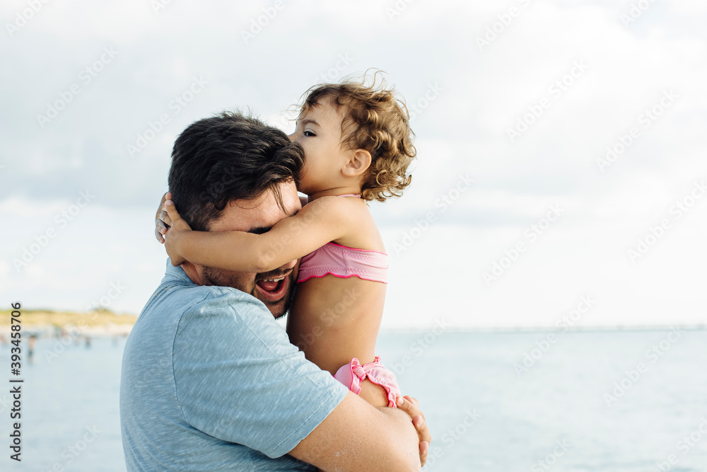 Father hugging daughter near sea Father hugging daughter near sea