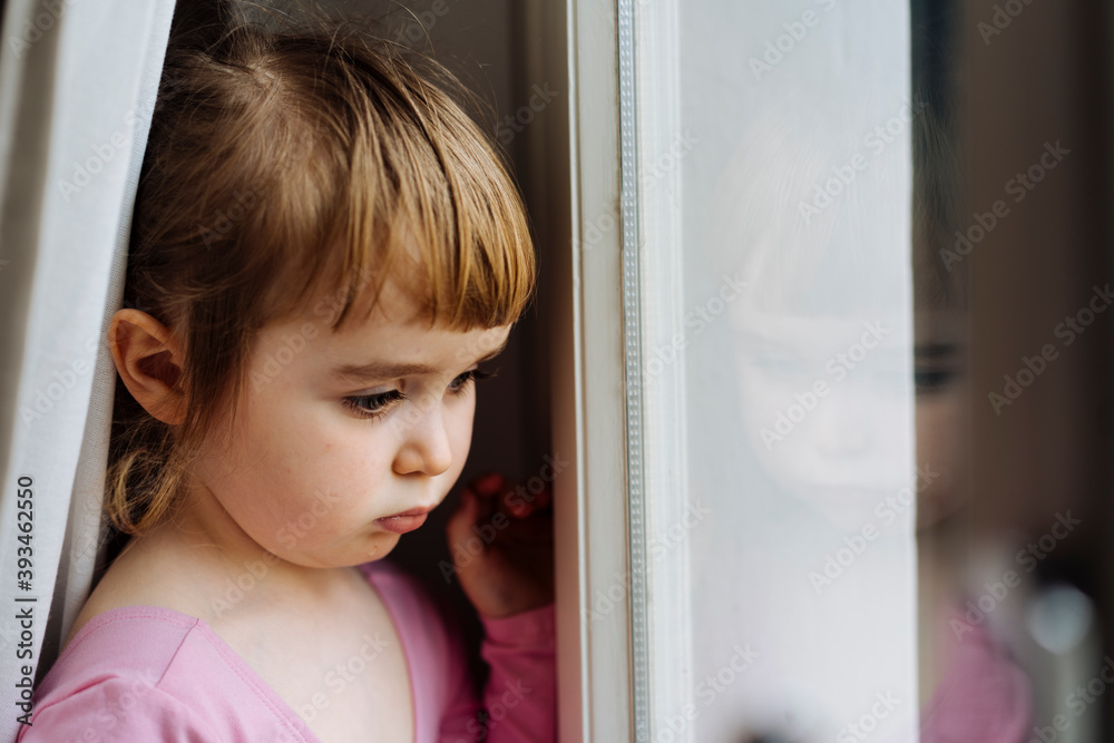 Sad little kid looking at window Sad little kid looking at window