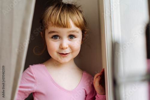 Cute little girl looking through window