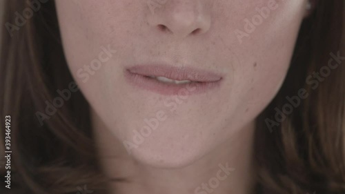 Close-up of young unidentified european woman wiping her mouth with napkin while sitting in cafe on background of blurry sparkles. Hygiene and good nutrition concept. Slow motion