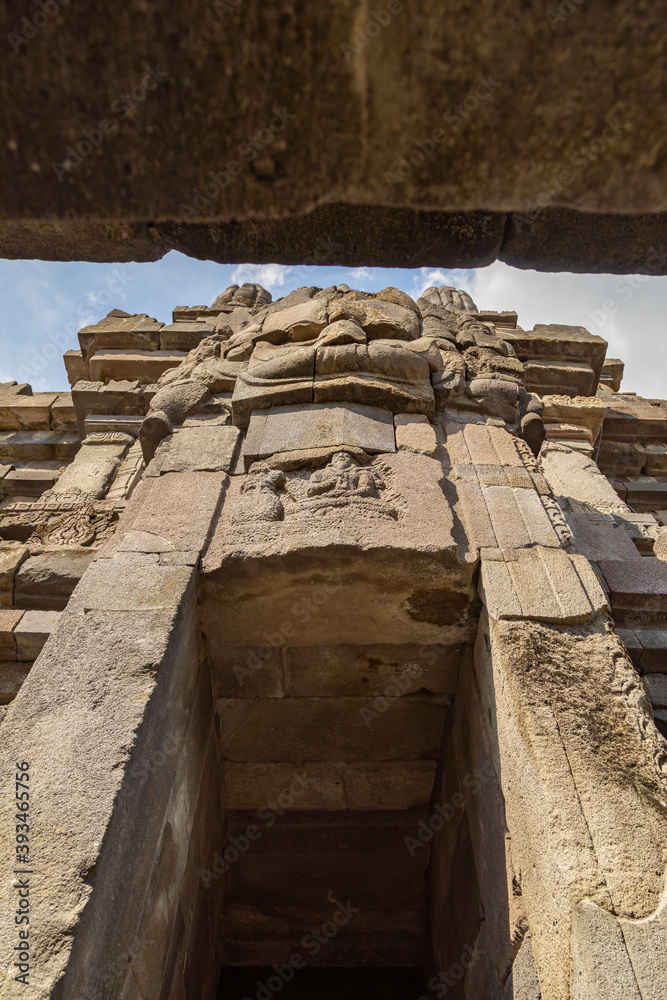 Fototapeta premium Huge carved stone face, in one of the shrines of the Prambanan ancient Hindu temple complex, Rara Jonggrang, in the Special, Yogyakarta region, Indonesia.