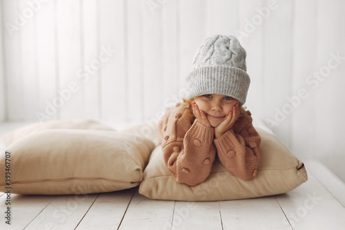 Child in a studio. Little girl at home. Girl in a brown sweater. photo