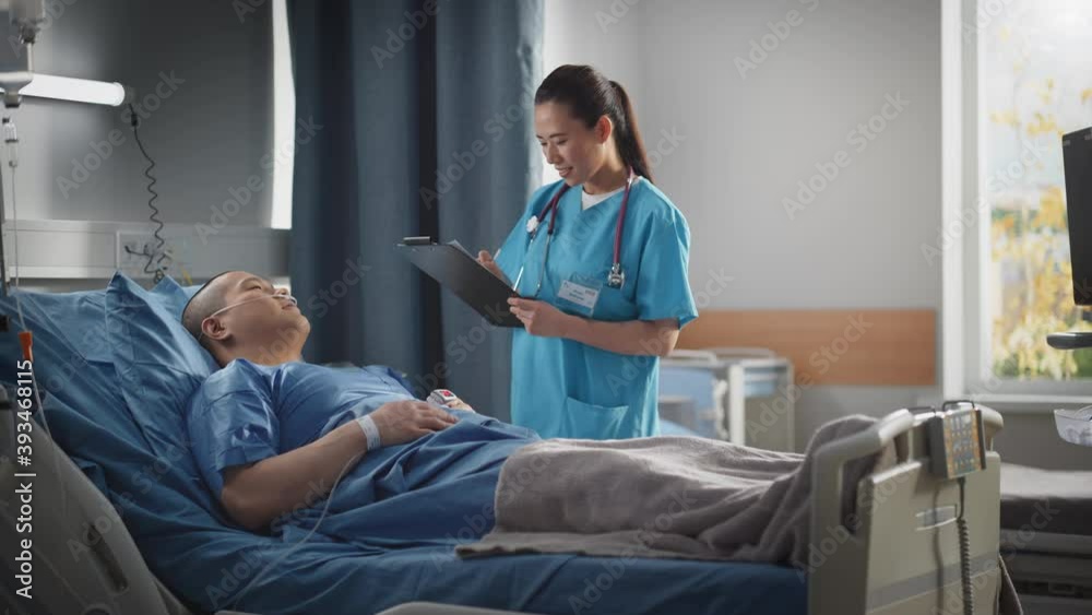 Hospital Ward: Friendly Chinese Head Nurse Fills Medical History Form, Talks to Male Patient Recovering in Bed. Beautiful Professional Nurse Helps Handsome Man Getting Better after Surgery. Hospital Ward: Friendly Chinese Head Nurse Fills Medical History Form, Talks to Male Patient Recovering in Bed. Beautiful Professional Nurse Helps Handsome Man Getting Better after Surgery.