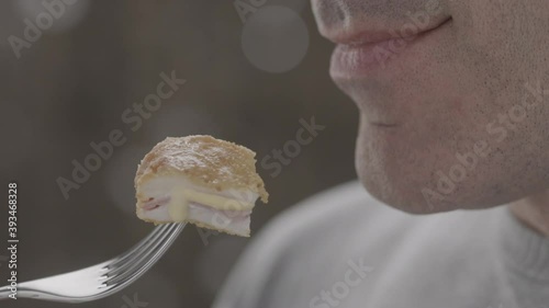 Close-up side view of young positive european woman taking a bite of yellow bell pepper on a shining background. Healthy vegetarian food concept. Slow motion