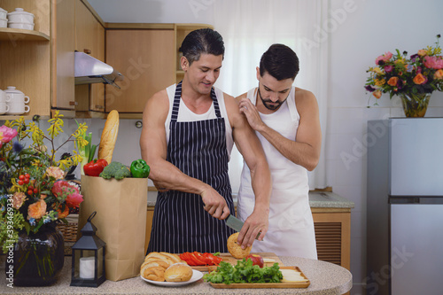 lgbtq gay couple enjoying cooking food together in kitchen