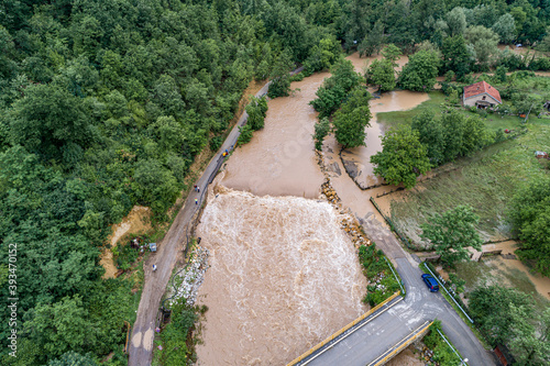 A river that overflows threatens the road bridge and property
