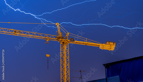 lightning over construction crane in the city
