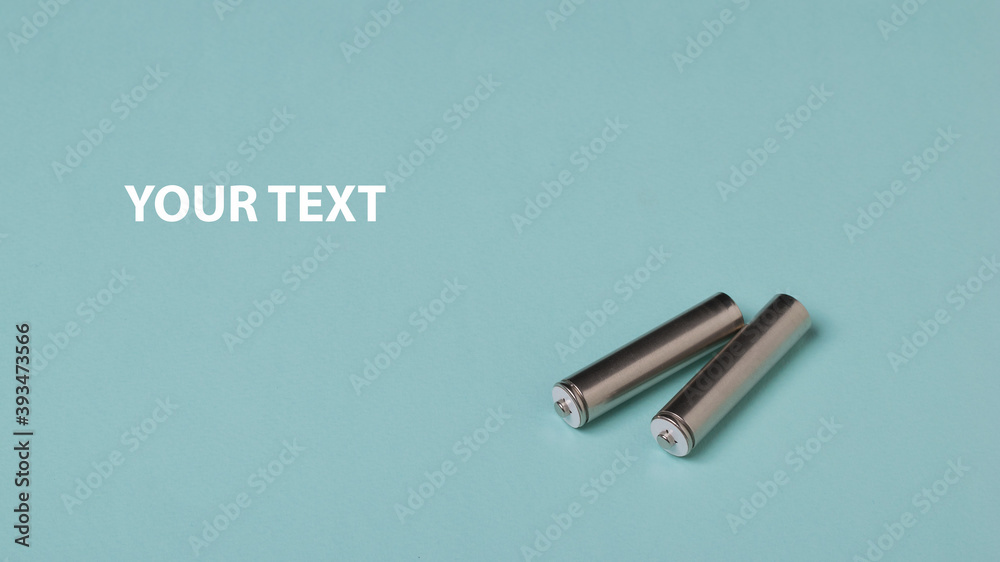 Two AA batteries on a blue background. Space for text. Two AA batteries on a blue background. Space for text.
